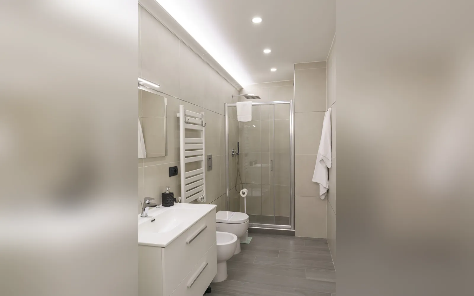 Il bagno con il box doccia, il lavabo e il termoarredo