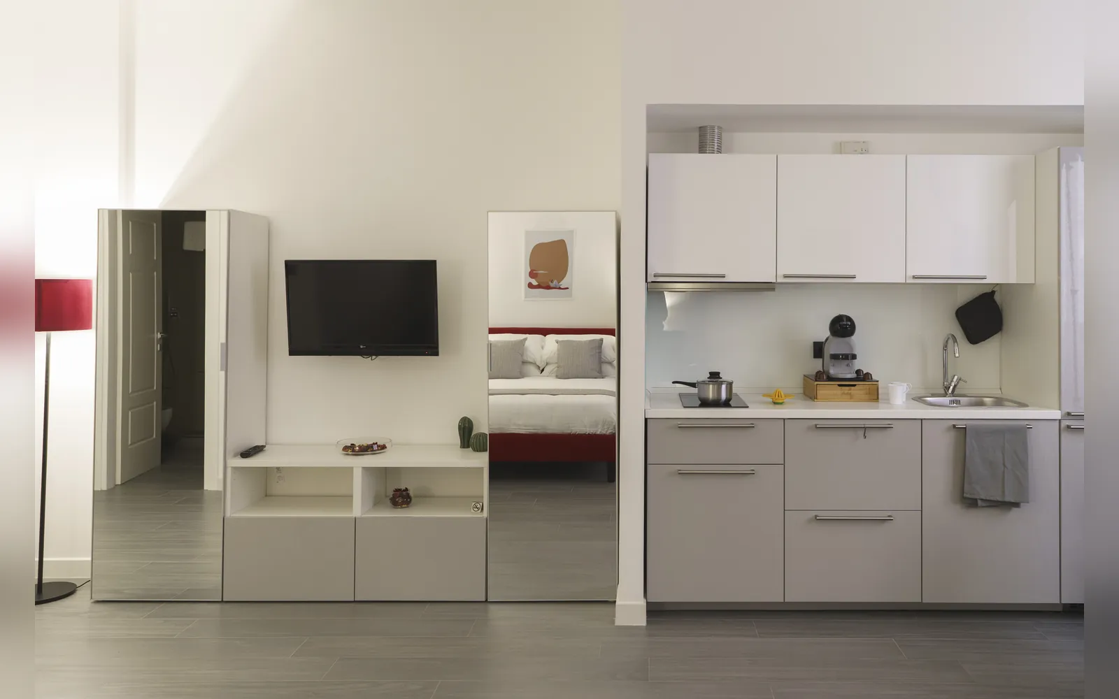 La TV a parete e l’angolo cottura bianco