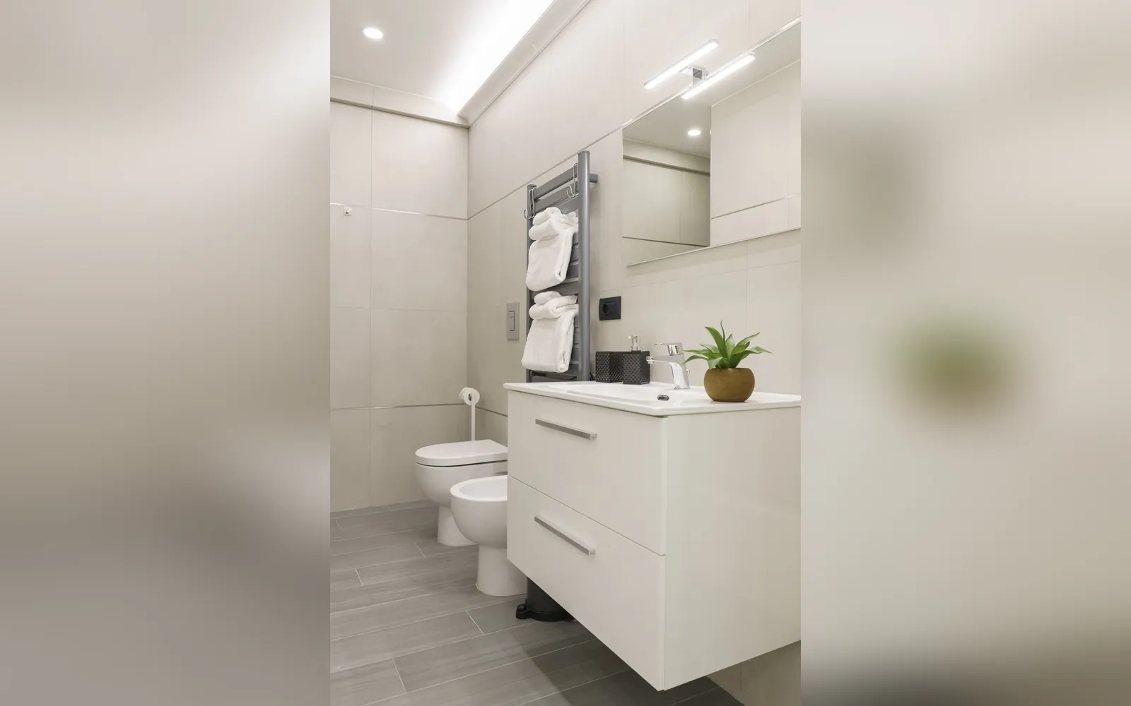 Il bagno con il lavabo sospeso, il bidet e il termoarredo