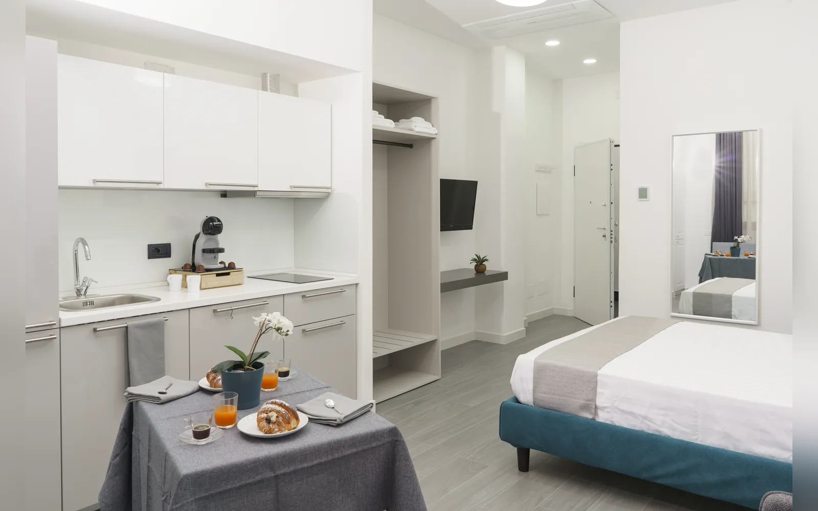 L’angolo cottura con il tavolo e, sullo sfondo, il letto